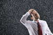 Businessman running hands through wet hair, standing in the Rain