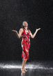 Woman, arms raised, smiling, standing in rain