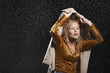 Businesswoman covering head with jacket during rainstorm