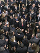 Photo: Large group of business people clapping, surrounding woman looking up, elevated view Large group of business people clapping, surrounding woman looking up, elevated view