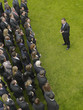Photo: Business man facing large group of business people in formation, elevated view Business man facing large group of business people in formation, elevated view