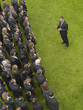 Photo: Business man facing large group of business people in formation, elevated view Business man facing large group of business people in formation, elevated view