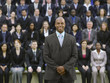 Business man standing in front of business people sitting in bleachers, portrait
