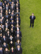 Photo: Business man standing next to large group of business people in formation, elevated view, portrait Business man standing next to large group of business people in formation, elevated view, portrait