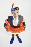 Photo: Middle-aged businessman in flippers, inflatable rubber ring, snorkel and goggles Middle-aged businessman in flippers, inflatable rubber ring, snorkel and goggles