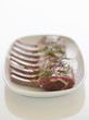 Plate of Fresh, raw Ribs with rosemary sprinkled on it