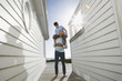 Grandfather giving grandson piggyback in passageway between houses