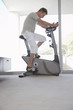 Mature man on exercise bike, pedalling, side view