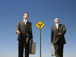 Two businessmen walking past road sign