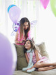 Foto: Two girls 7-9, 10-12 on sofa in party costumes, one adjusting other's tiara Two girls 7-9, 10-12 on sofa in party costumes, one adjusting other's tiara