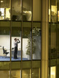 Business man using binoculars in office, view from building exterior