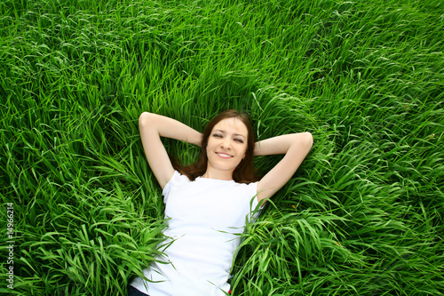 Photo: beautiful girl lying down of grass beautiful girl lying down of grass
