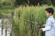 Boy 7-9 fishing in river