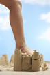 Photo: Child stepping on sand castle, low section Child stepping on sand castle, low section