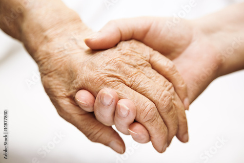 Photo: adult helping senior in hospital adult helping senior in hospital