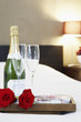 Champagne and flutes on bed