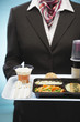 Stewardess holding tray with airplane food, mid section
