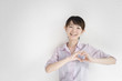 ハートマークを胸元に作る女性