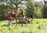 Photo: Young boy 7-9 in pirate costume pushing boy 5-6 in cart in jaguar costume, smiling Young boy 7-9 in pirate costume pushing boy 5-6 in cart in jaguar costume, smiling