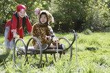 Photo: Portrait of boy 7-9 wearing pirate costume pushing boy 5-6 in cart in jaguar costume, garden Portrait of boy 7-9 wearing pirate costume pushing boy 5-6 in cart in jaguar costume, garden