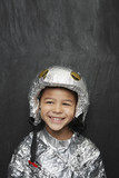 Photo: Portrait of young boy 5-6 in aluminum foil astronaut costume, smiling, studio shot Portrait of young boy 5-6 in aluminum foil astronaut costume, smiling, studio shot