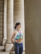 Foto: Female athlete wearing gold medal, standing in portico Female athlete wearing gold medal, standing in portico