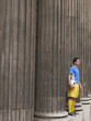 Foto: Soccer player holding ball, standing between columns, side view Soccer player holding ball, standing between columns, side view
