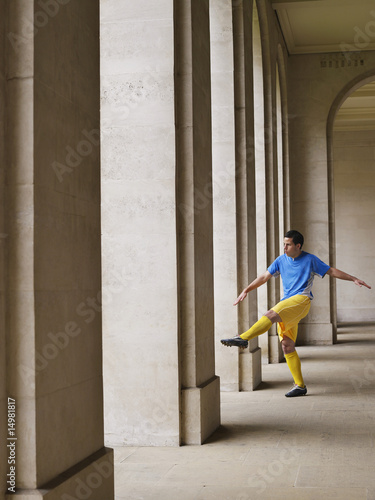 Photo: Soccer player kicking ball in portico Soccer player kicking ball in portico