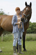 Woman with horse in field, portrait