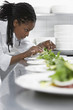 Female chef preparing salad in kitchen