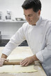 Chef rolling dough in kitchen