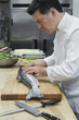 Male chef preparing salmon in kitchen