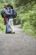Couple embracing on forest road, side view
