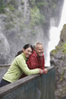 Man and woman looking at view near waterfall, woman embracing man