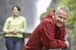 Man and woman in mountains, focus on man leaning on railing