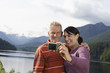 Couple photographing selves, mountains in background