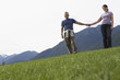 Portarit of couple holding hands, mountain range in background