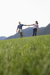 Couple holding hands, grass in foreground