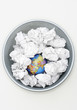 Waste bin with globe among crumpled papers, view from above
