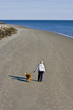 Woman Walking Dog on Beach