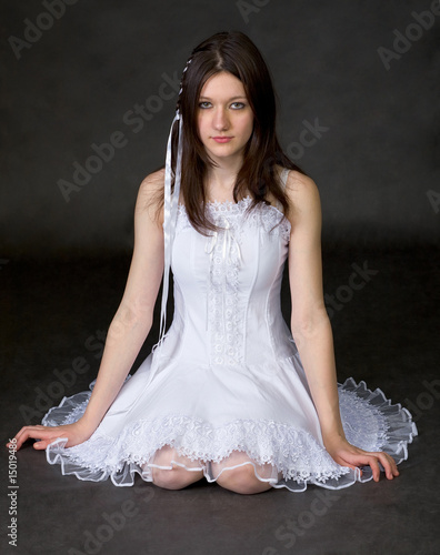 Photo: Girl in white dress sits on a black Girl in white dress sits on a black