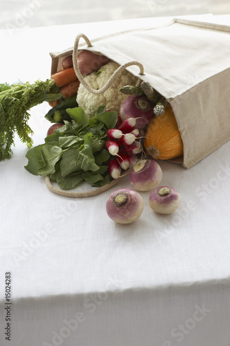 Photo: Bag full of fresh vegetables on table, close-up Bag full of fresh vegetables on table, close-up