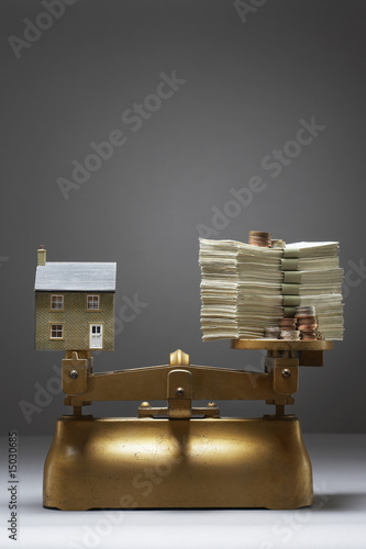 Photo: Model house and money on scales Model house and money on scales