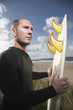 Man holding surfboard on beach