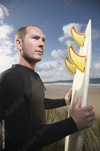 Photo: Man holding surfboard on beach Man holding surfboard on beach