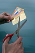 Hands cutting credit cards with scissors