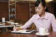 Business woman writing in diary, sitting in cafe
