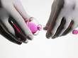 Photo: Person wearing rubber gloves pouring pink liquid into vial, close up, studio shot Person wearing rubber gloves pouring pink liquid into vial, close up, studio shot