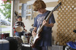 Two boys 10-12 playing drums and guitar in garage