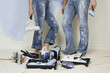 Couple resting while painting wall, low section